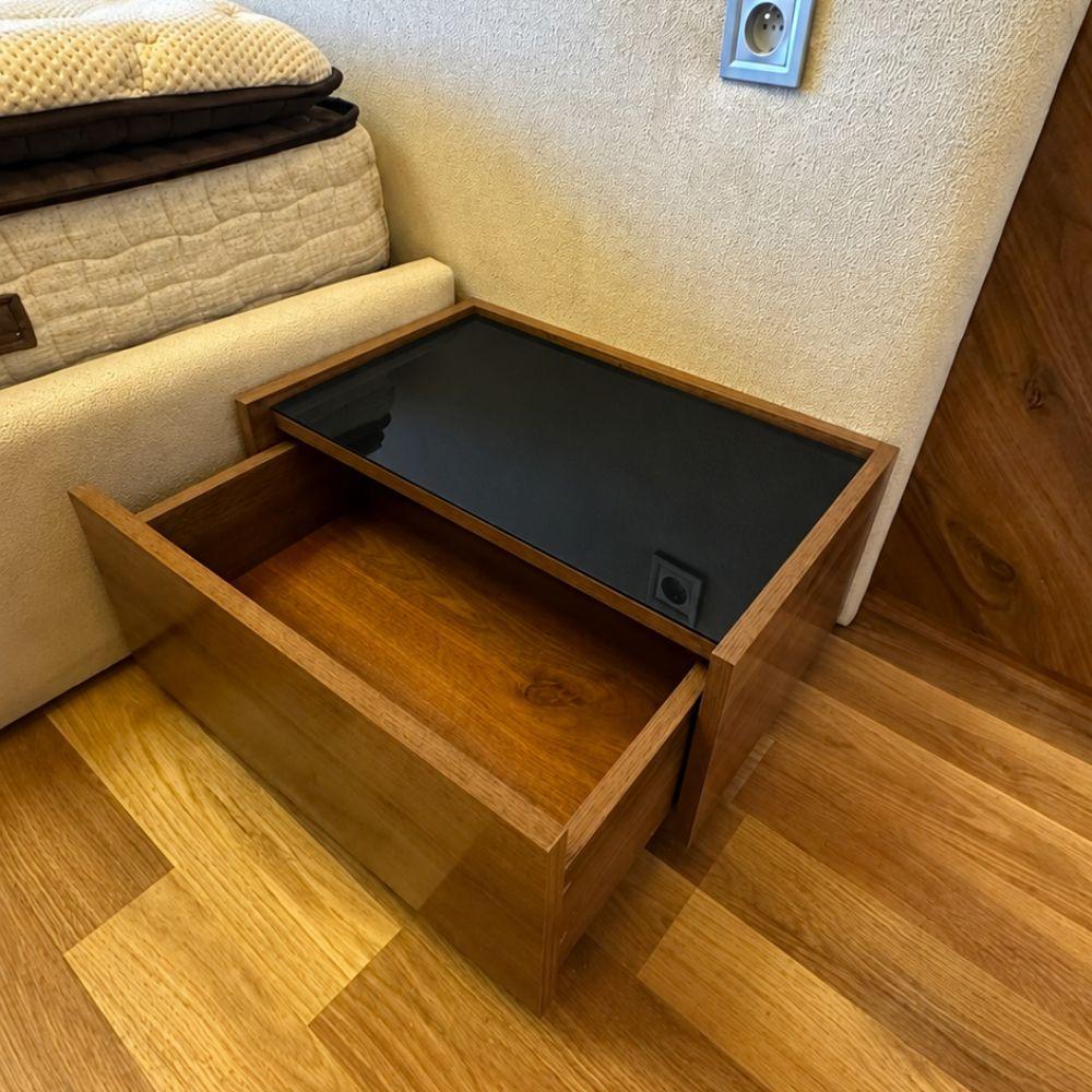 Table de chevet ONYX Dar Al Azizi en bois avec plateau en verre noir fumé dans une chambre moderne